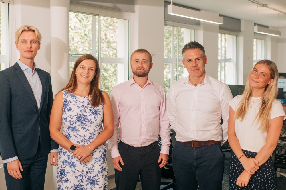 A photo of five our new recent joiners smiling to the camera in our London office. From left to right: Stian, Helen, Oliver, David and Emily