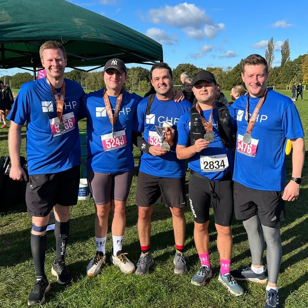 5 CHP runners, pictured in blue CHP tshirts smile after completing the RIchmond Half Marathon to raise funds for men's health.